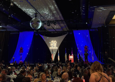 Similar wide-angle shot of the gala ballroom filled with guests, patriotic décor, and stage in the background during the WNY Heroes charity event.