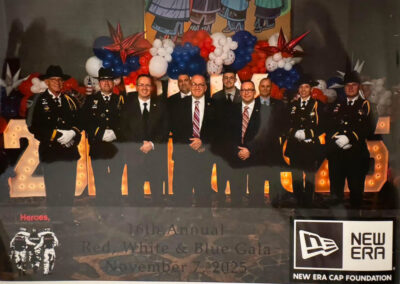 Group photo of event honorees and uniformed personnel in front of red-white-blue balloons and illuminated “2025” sign at the 16th Annual Red, White & Blue Gala, November 7, 2025.